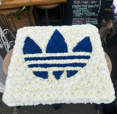 Adidas Logo Tribute - A bespoke funeral tribute featuring the iconic Adidas design, handcrafted in bold blue and classic white for a personal and meaningful farewell.