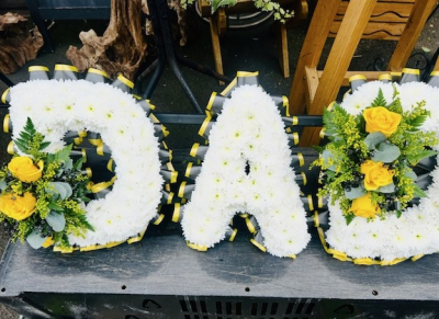 Yellow Dad Tribute - A classic DAD funeral letter tribute in white, beautifully finished with yellow floral clusters and coordinating ribbon for a heartfelt farewell.