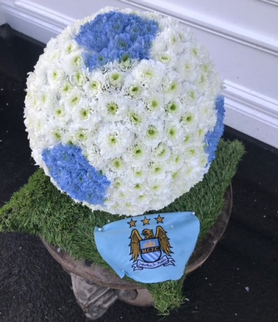 Football Tribute - A bespoke football-shaped funeral tribute in blue and white, personalised with Manchester City details for a meaningful and heartfelt farewell.