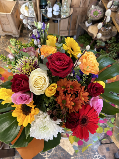 Colour Fusion - A spectacular arrangement bursting with bold, vibrant colours and statement blooms, finished with lush tropical foliage.