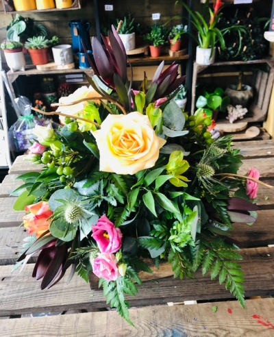 Natural Tribute Posy - A natural funeral posy featuring soft peach and pink tones with abundant greenery and rich botanical textures.