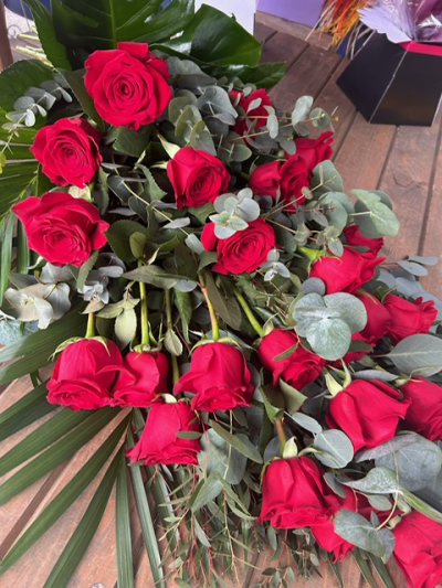 Eternal Love Sheaf - An elegant funeral sheaf of rich red roses, beautifully arranged with eucalyptus and lush foliage for a classic heartfelt tribute.
