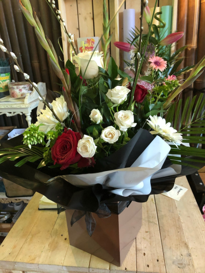 Timeless Romance - A striking box arrangement of rich red and classic white blooms, beautifully framed with lush greenery.