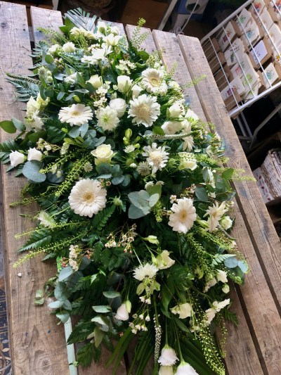 Pure Grace Spray - An elegant white and green casket spray, beautifully arranged with delicate blooms, eucalyptus and flowing foliage.