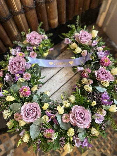 Everlasting Love Horseshoe - A beautiful horseshoe funeral tribute featuring soft purple, pink and cream blooms, finished with fresh greenery and a personalised ribbon.