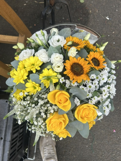 Yellow Funeral Posy - A bright funeral posy featuring vibrant yellow, orange and white blooms, beautifully complemented by soft greenery.