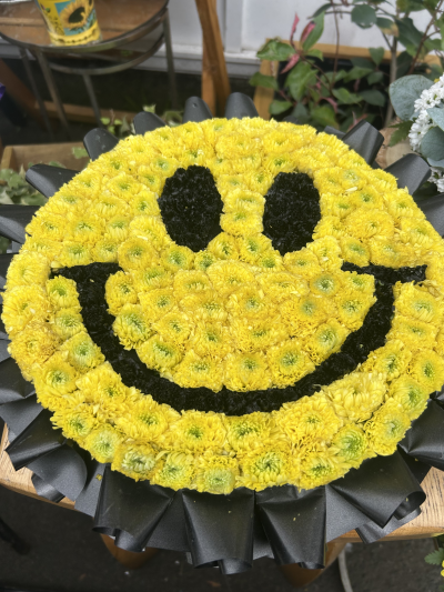 Acid House Smiley Face - A bold and vibrant smiley face floral tribute, handcrafted with care by Virginia Carmen Designs in Bolton.